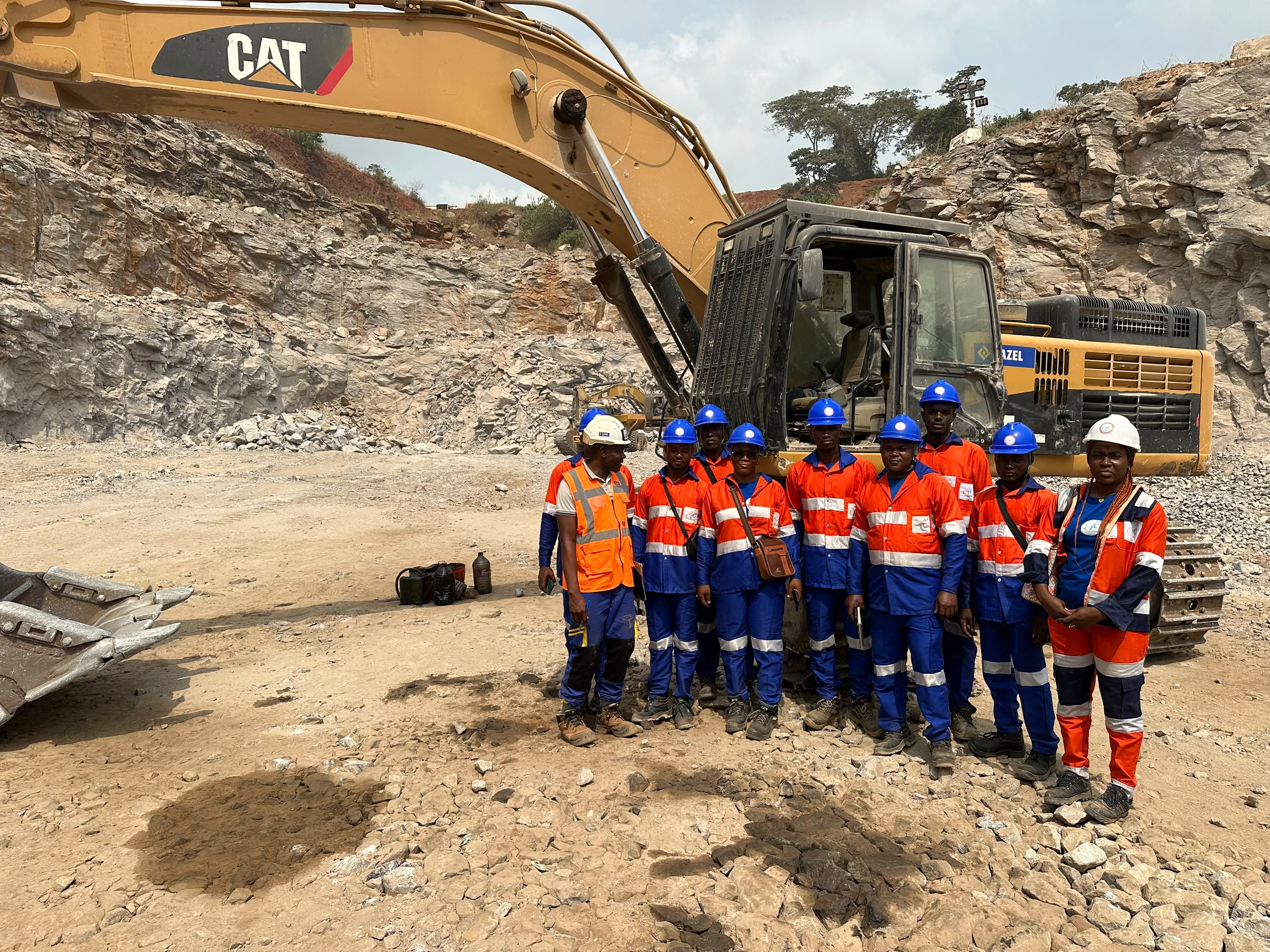 Équipe de stagiaires CFP-CIC en EPI devant une pelle excavatrice sur chantier au Cameroun
